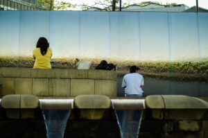 Down by the Station. A couple of people sat by the water feature outside Sheffield Train Station. Sheaf Square, Sheffie…